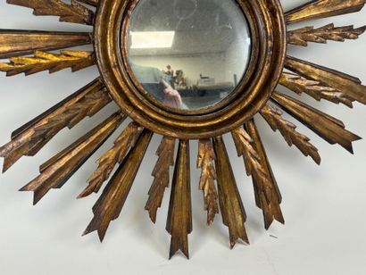 Radiating mirror in carved and gilded wood...
