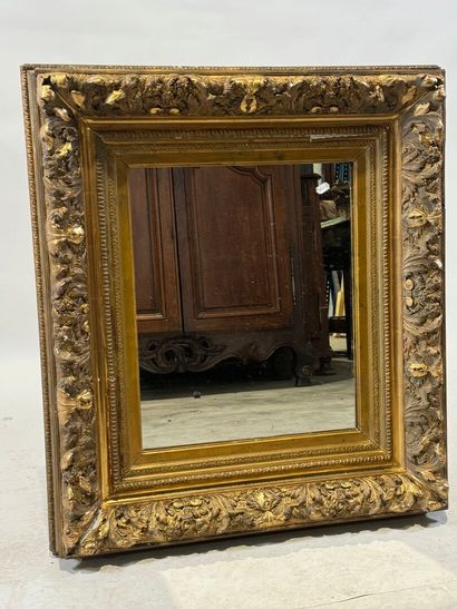 Wood and gilded stucco mirror with foliage...