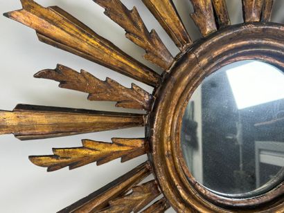 Radiating mirror in carved and gilded wood...