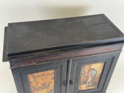 Small cabinet in blackened wood opening with...