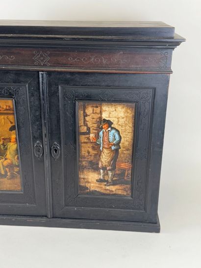 Small cabinet in blackened wood opening with...