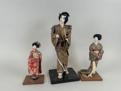 JAPON, XXe.
Trois poupées en bois laqué et...
