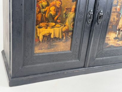 Small cabinet in blackened wood opening with...