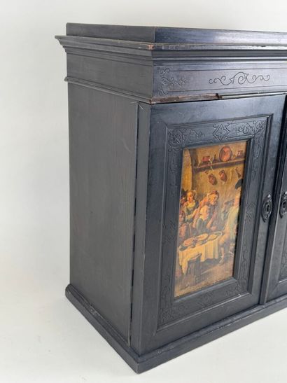 Small cabinet in blackened wood opening with...