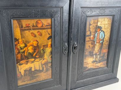 Small cabinet in blackened wood opening with...