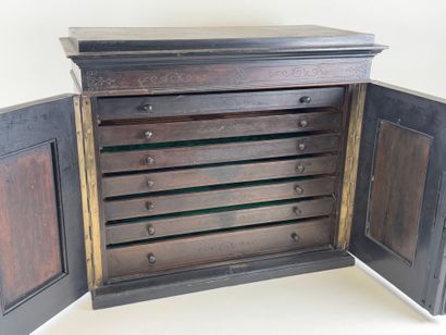 Small cabinet in blackened wood opening with...