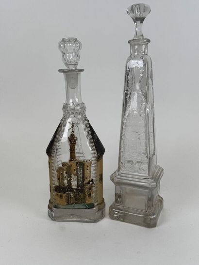 Two glass bottles decorated with an obelisk...