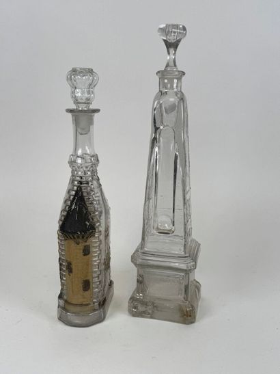 Two glass bottles decorated with an obelisk...