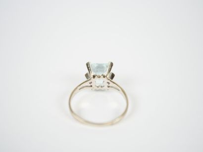 Platinum ring set with an emerald-cut faceted...