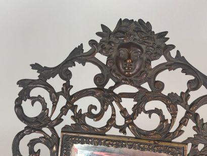 An openwork patinated bronze mirror with...
