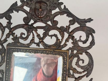 An openwork patinated bronze mirror with...