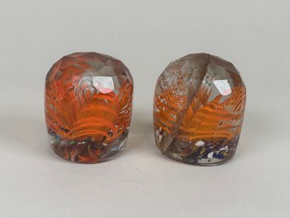 Two faceted and colored glass paperweight...