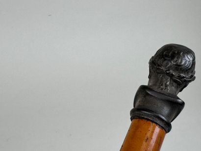 Canne en bois clair, le pommeau en régule...