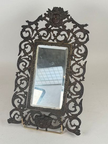 An openwork patinated bronze mirror with...