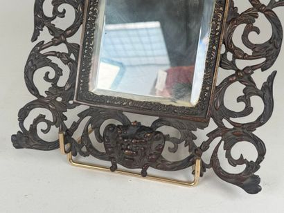 An openwork patinated bronze mirror with...
