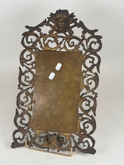 An openwork patinated bronze mirror with...