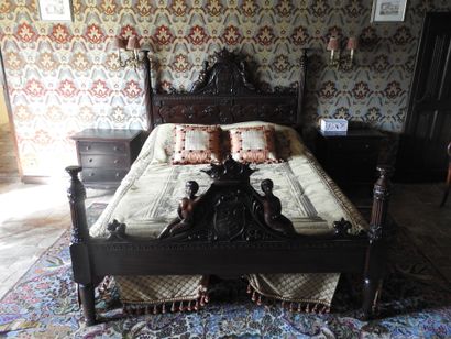 Large carved wood bed decorated with women...