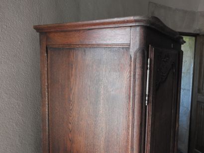 Small carved oak armoire, opening with two...