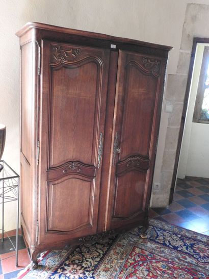 Small carved oak armoire, opening with two...