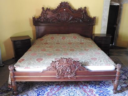 Large carved wood bed with figures and foliage.
181...