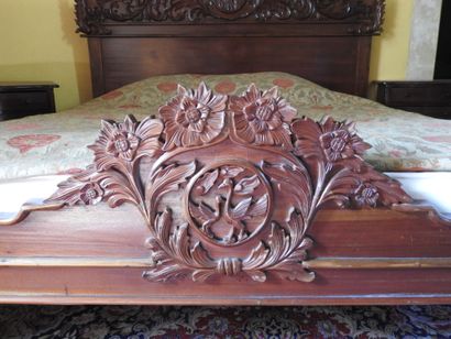 Large carved wood bed with figures and foliage.
181...