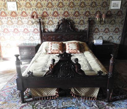 Large carved wood bed decorated with women...
