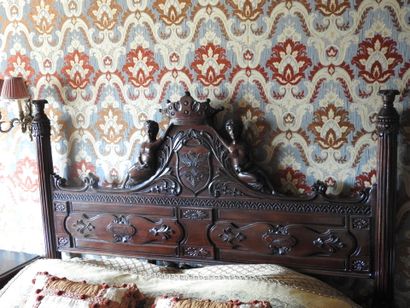 Large carved wood bed decorated with women...