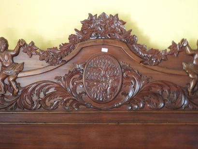 Large carved wood bed with figures and foliage.
181...