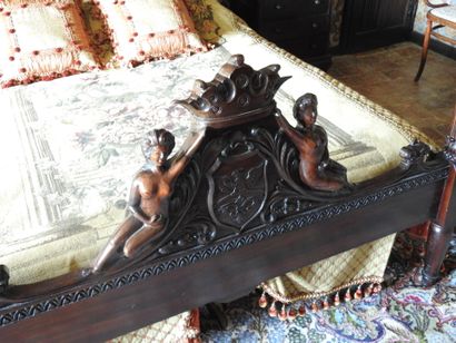 Large carved wood bed decorated with women...