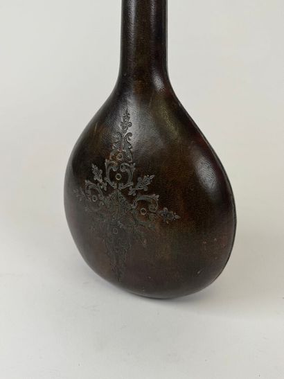 Leather-wrapped flask with small iron motif.
H....