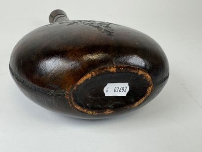 Leather-wrapped flask with small iron motif.
H....