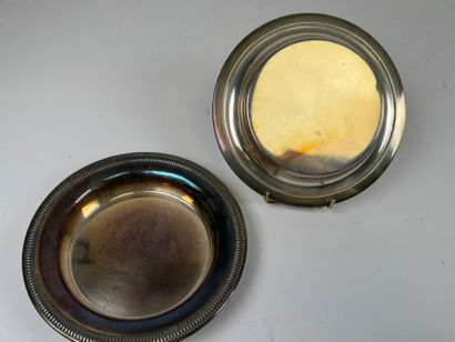 Two circular silver-plated coasters with...