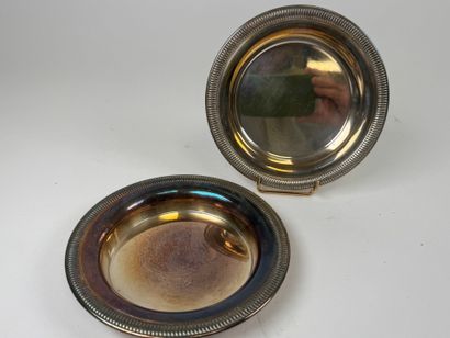 Two circular silver-plated coasters with...