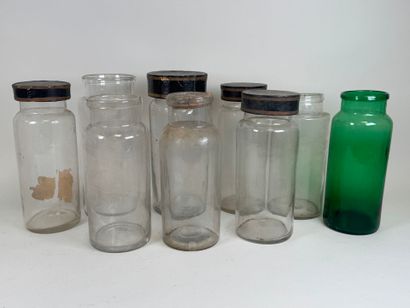 Nine glass medicine jars, one colored, with...
