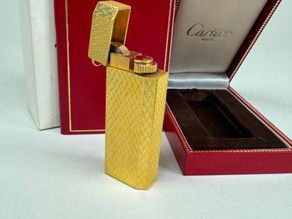 CARTIER. 
Briquet en métal doré guilloché,...