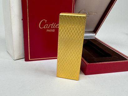 CARTIER. 
Briquet en métal doré guilloché,...