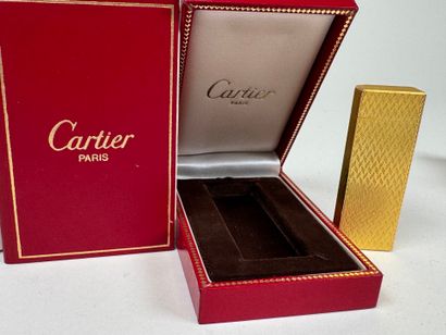 CARTIER. 
Briquet en métal doré guilloché,...