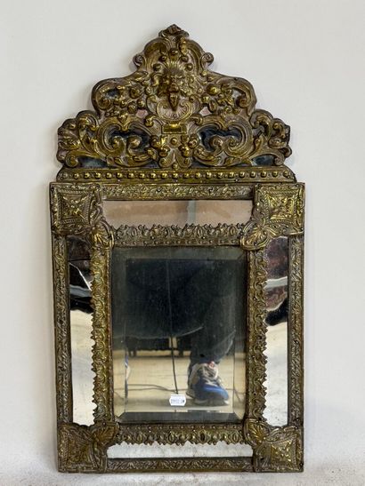 Embossed brass mirror with foliate scrolls.
58...