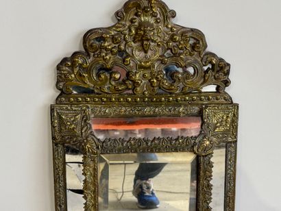 Embossed brass mirror with foliate scrolls.
58...