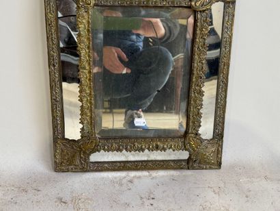 Embossed brass mirror with foliate scrolls.
58...