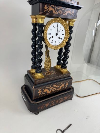 A portico clock in blackened wood with light...