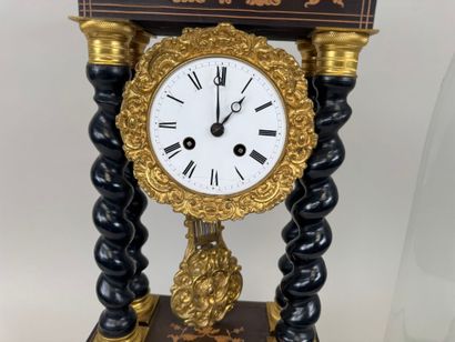 A portico clock in blackened wood with light...