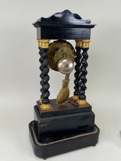 A portico clock in blackened wood with light...