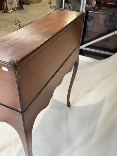 A slanted desk that opens via a leather-covered...