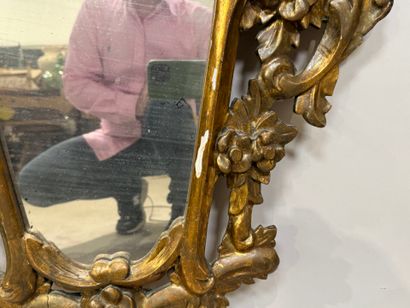 Gilded and openworked wood and stucco mirror...