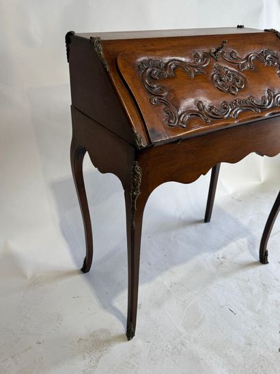 A slanted desk that opens via a leather-covered...