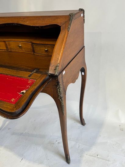 A slanted desk that opens via a leather-covered...