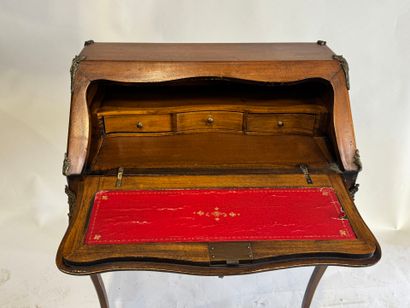 A slanted desk that opens via a leather-covered...