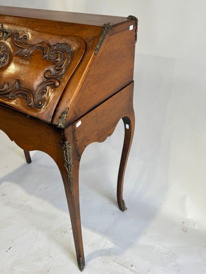 A slanted desk that opens via a leather-covered...