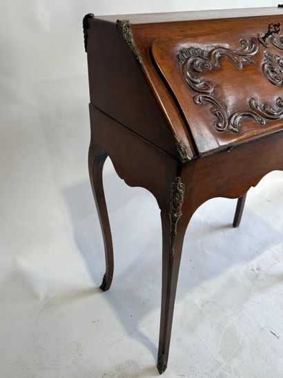 A slanted desk that opens via a leather-covered...